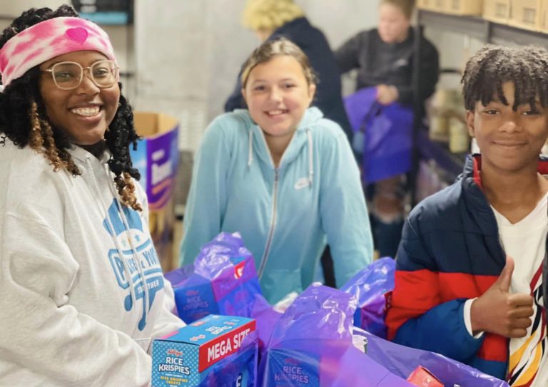 Group volunteers helping to make food bags at our location